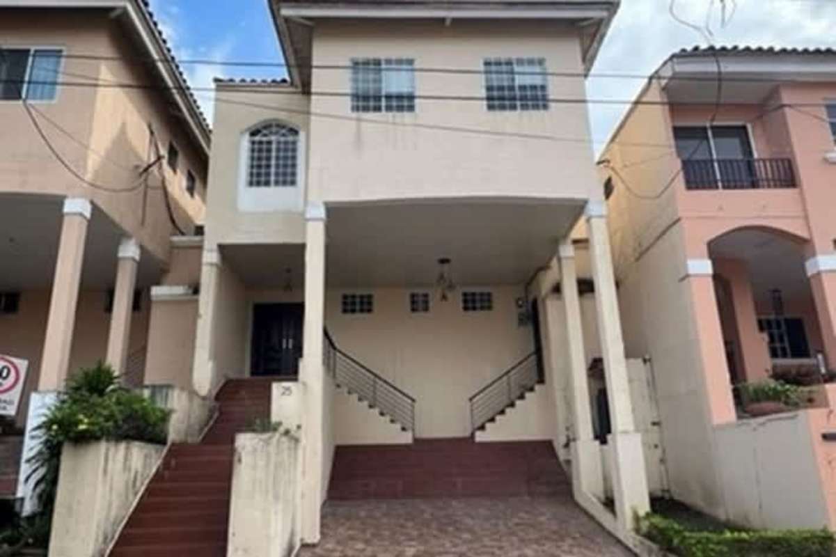 Two-story townhouse facade with carport in Urbanization El Doral Panama