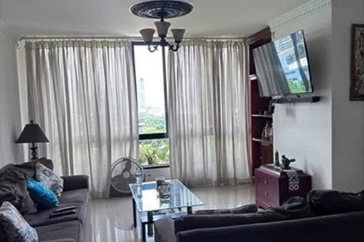 Living room with sofas, mounted TV, balcony access in PH Punta Paitilla Panama City