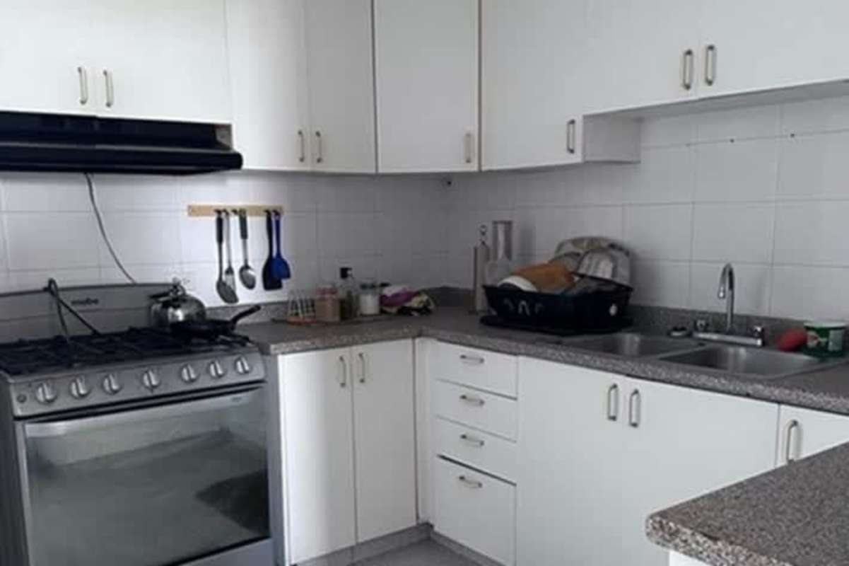 White kitchen with granite countertops and stainless steel appliances at PH Punta Paitilla Panama City