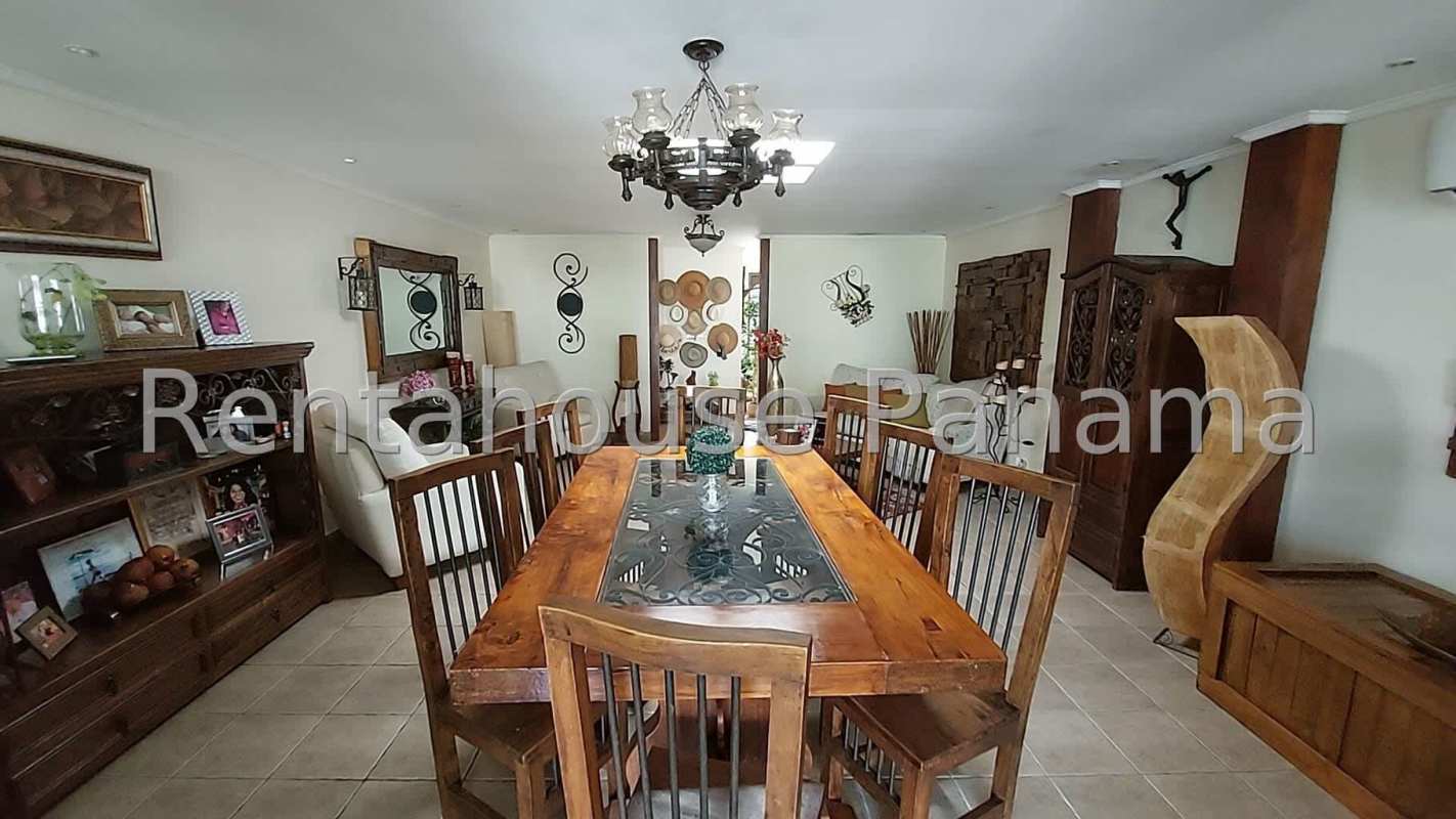 Dining room with traditional wooden furniture and chandelier in spacious home for sale Panama