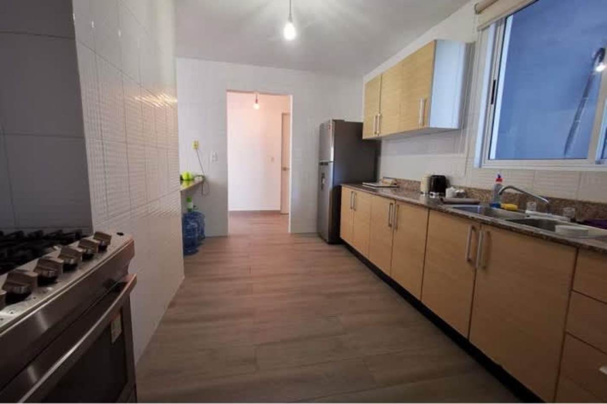 Modern kitchen with granite counters, wood cabinets in furnished loft PH Blue Park Bella Vista Panama