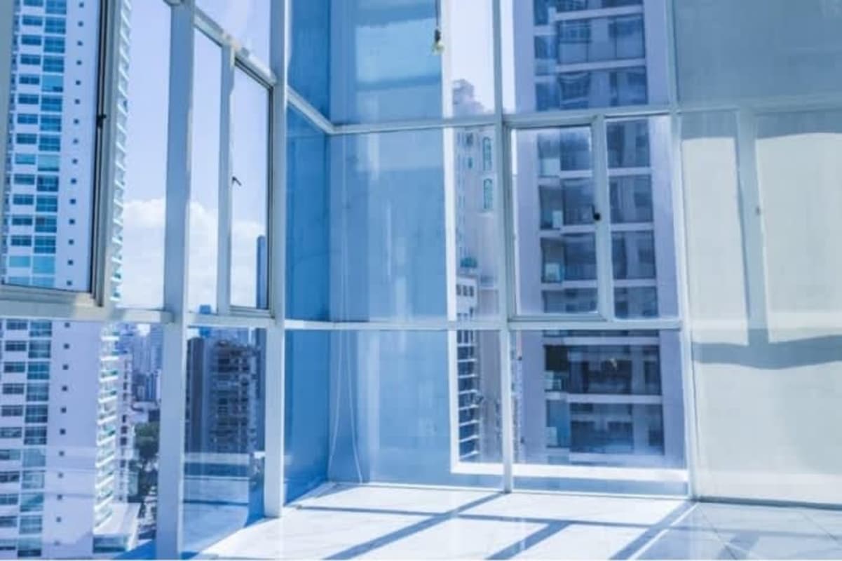 Modern living room with floor to ceiling windows overlooking Panama City skyline in PH Blue Park Bella Vista