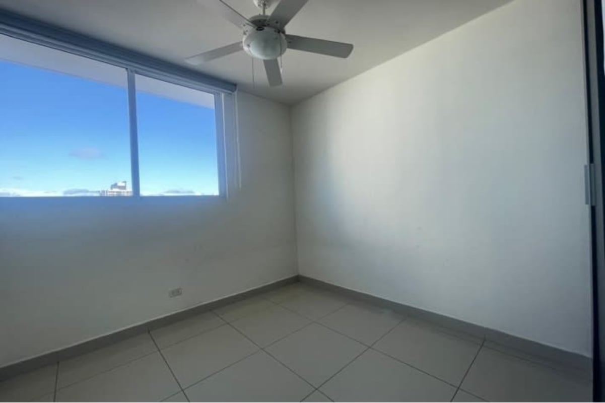 Bedroom with city view, built-in wardrobe, and ceiling fan at Torres de La Loma Panama
