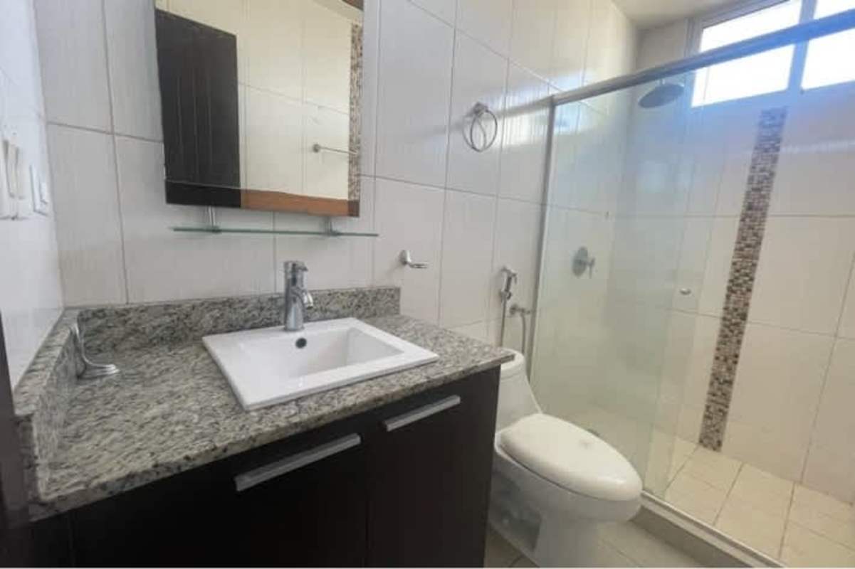Empty bedroom with panoramic windows and city skyline view in Torres de La Loma Panama