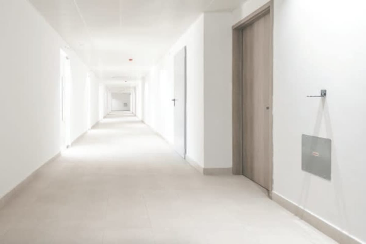 Well-lit minimalist corridor in medical building with multiple office doors Park Square Panama
