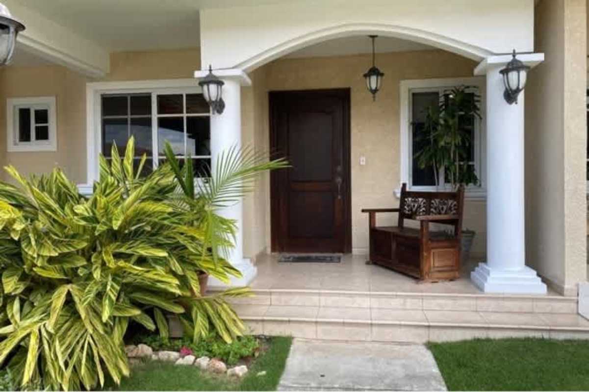 Outdoor terrace with wicker sofa, dining area, tropical plants in Palmeras del Este house Costa del Este