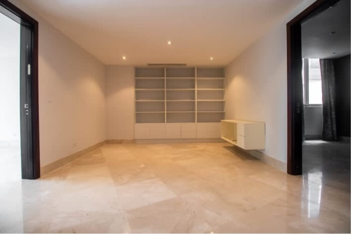 Empty living room with marble floors, built-in shelves and cabinet PH Miradores Panama City