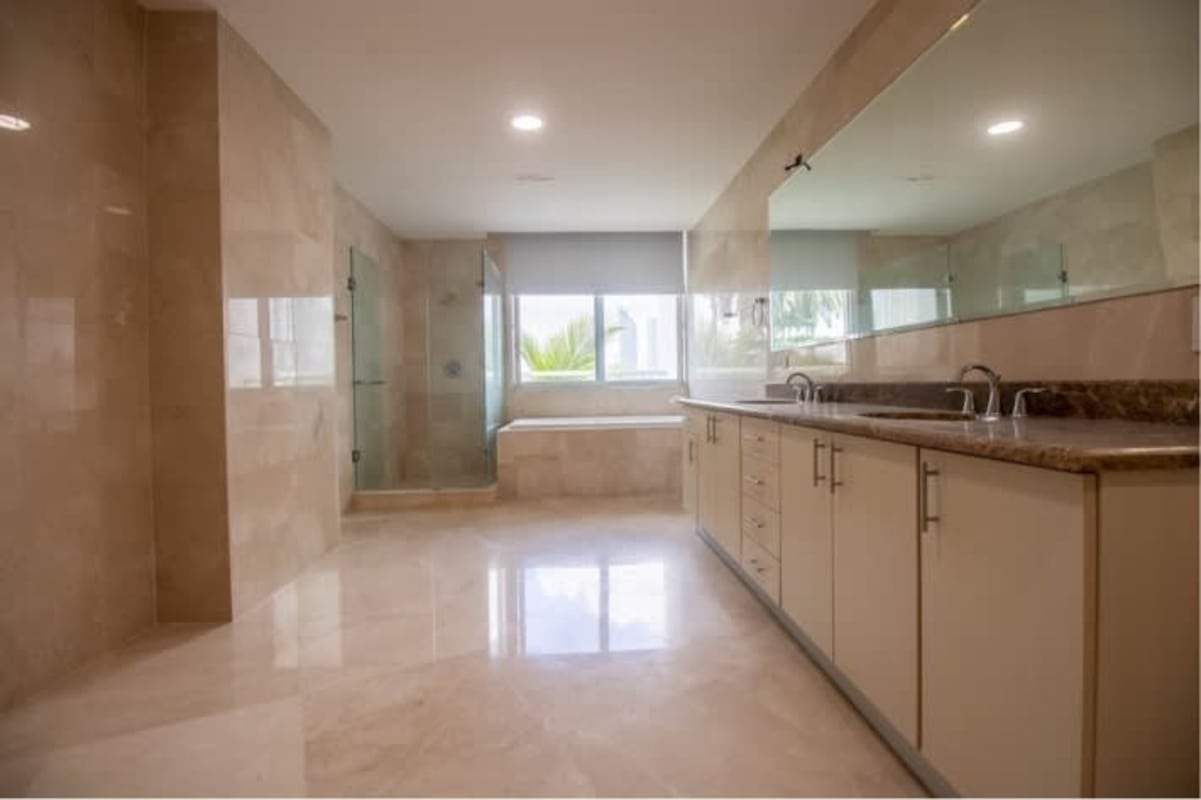 Modern bathroom with double sink, marble walls, bathtub and shower in PH Miradores Punta Pacifica