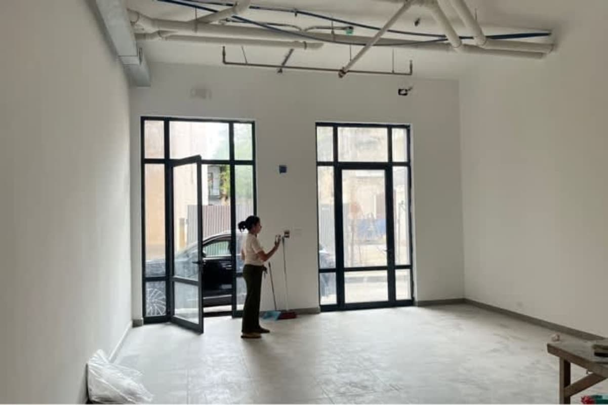 Minimalist white tiled bathroom with wall sink in Casco Viejo commercial space Panama