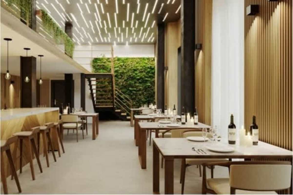Upscale restaurant space with double-height ceiling, greenery wall, and contemporary decor in Casco Viejo Panama