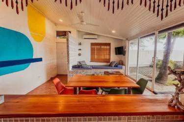 Modern tropical living dining area with sliding glass doors and ocean views Playa Malibú Panama