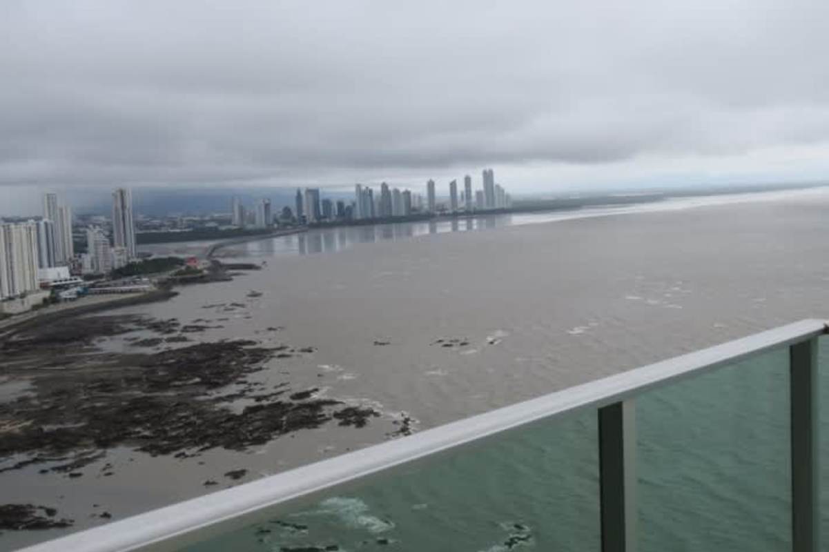 Modern apartment living room with panoramic ocean views through large glass windows Costa Pacifica Panama