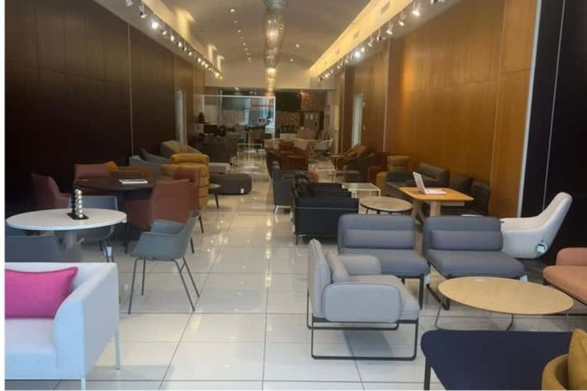 Minimalist cafeteria area with white tables, black chairs and decorative panel wall Commercial Plaza Obarrio Panama