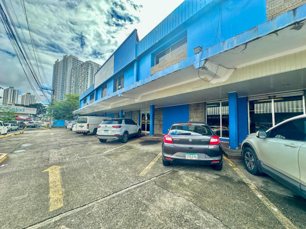 Urban commercial complex with parking lot and two-story blue facade in Panama City