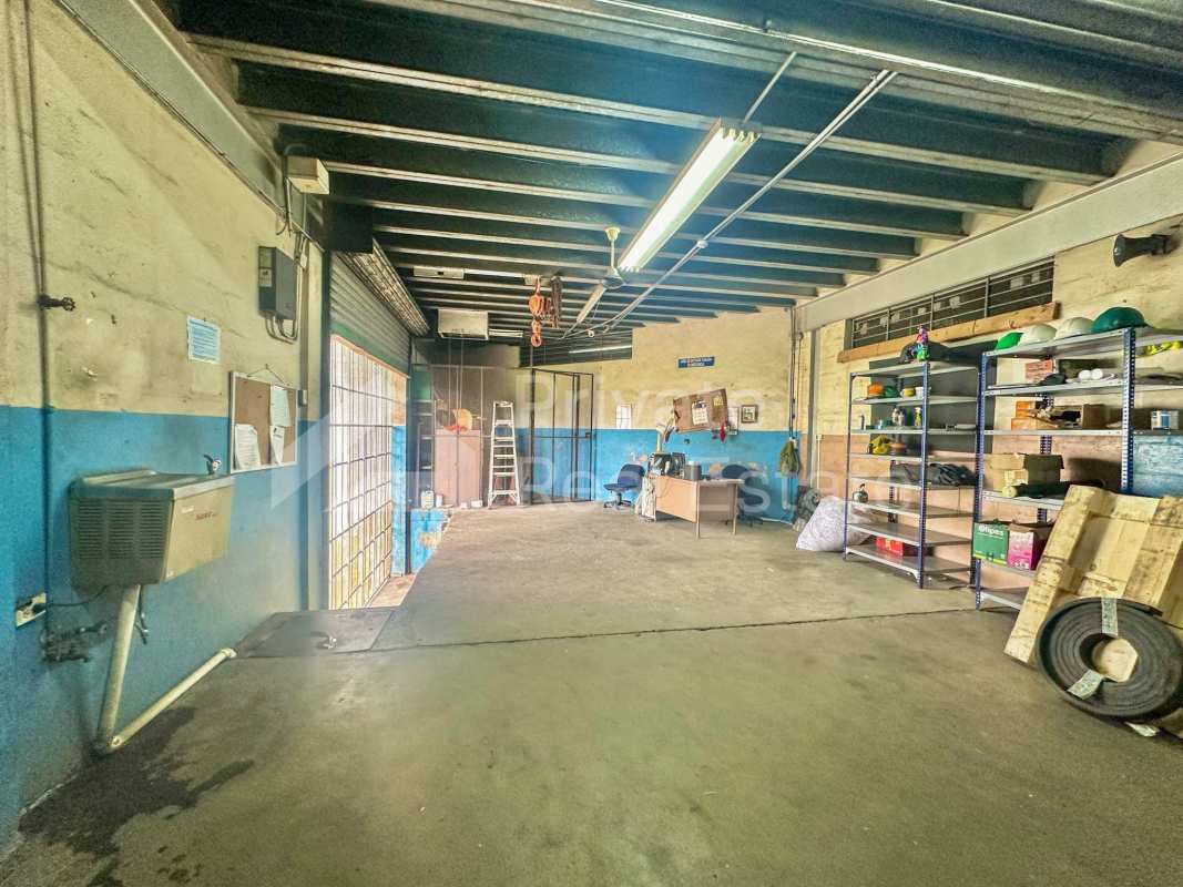 Interior of industrial warehouse with coiled hoses on floor, concrete surface, organized storage in Vista Hermosa Panama