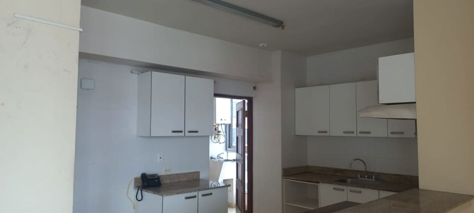 Modern white kitchen with granite counter and tile backsplash PH GrandBay Panama
