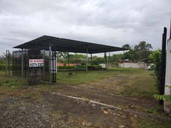 Vacant fenced commercial yard with open metal-roofed structure near Plaza Terronal Chiriquí Panama