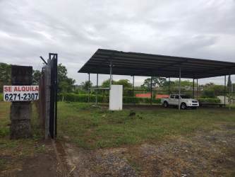 Open fenced commercial lot with gated entry and large open-sided canopy warehouse El Terronal David Panama