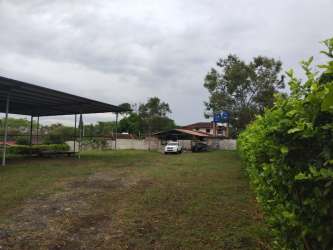Covered metal roof parking shed surrounded by open grassy yard in El Terronal David Panama