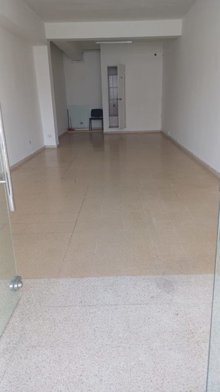 Empty commercial interior with glass front, tiled flooring, white walls Vista Hermosa