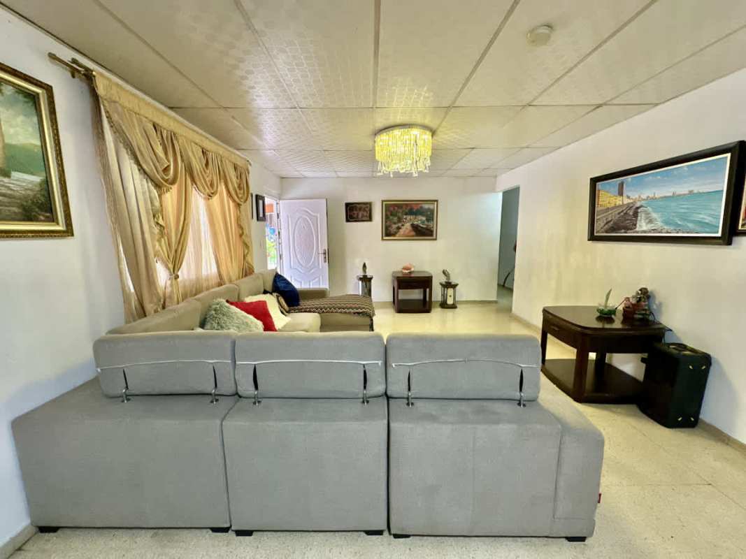 Living room with sectional sofa, chandelier and floral curtains at Campo Verde Las Cumbres