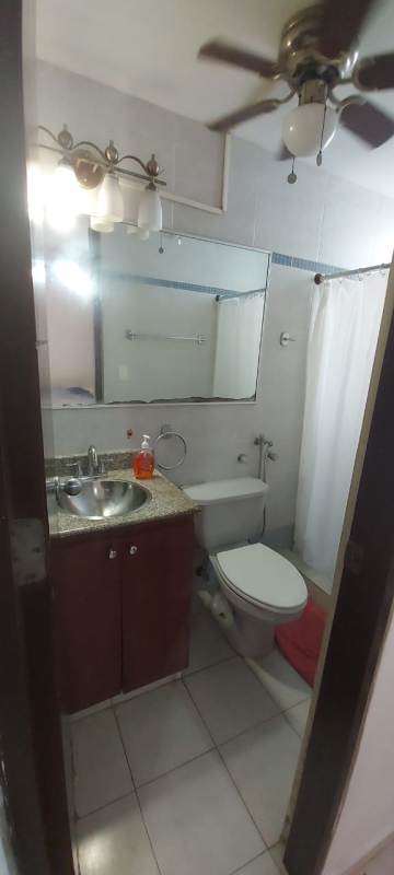 Bathroom with vanity, large mirror, walk-in shower and tiled walls in McGregor Point Condado del Rey Panama