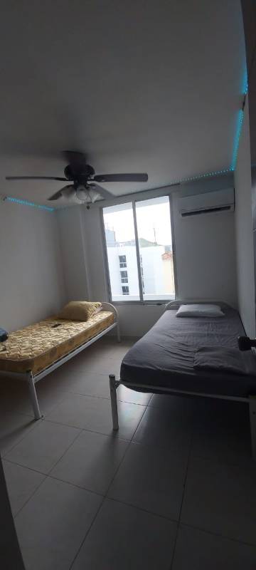 Simple bedroom design with large window, bed, ceiling fan and wardrobe in Condado del Rey Panama