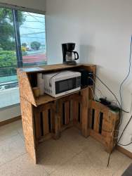 Rustic DIY kitchenette with microwave and coffee maker in commercial property