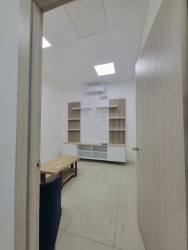 Spacious lobby area with floor-to-ceiling windows, open mezzanine, glass stair rails at Plaza Leonardo