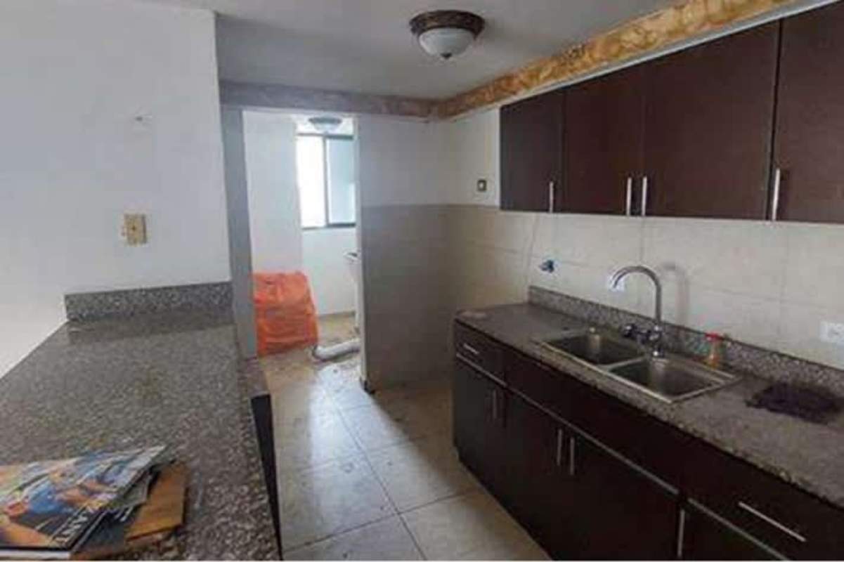 Modern kitchen with granite countertops dark wood cabinetry split sink in PH Condado Country Club