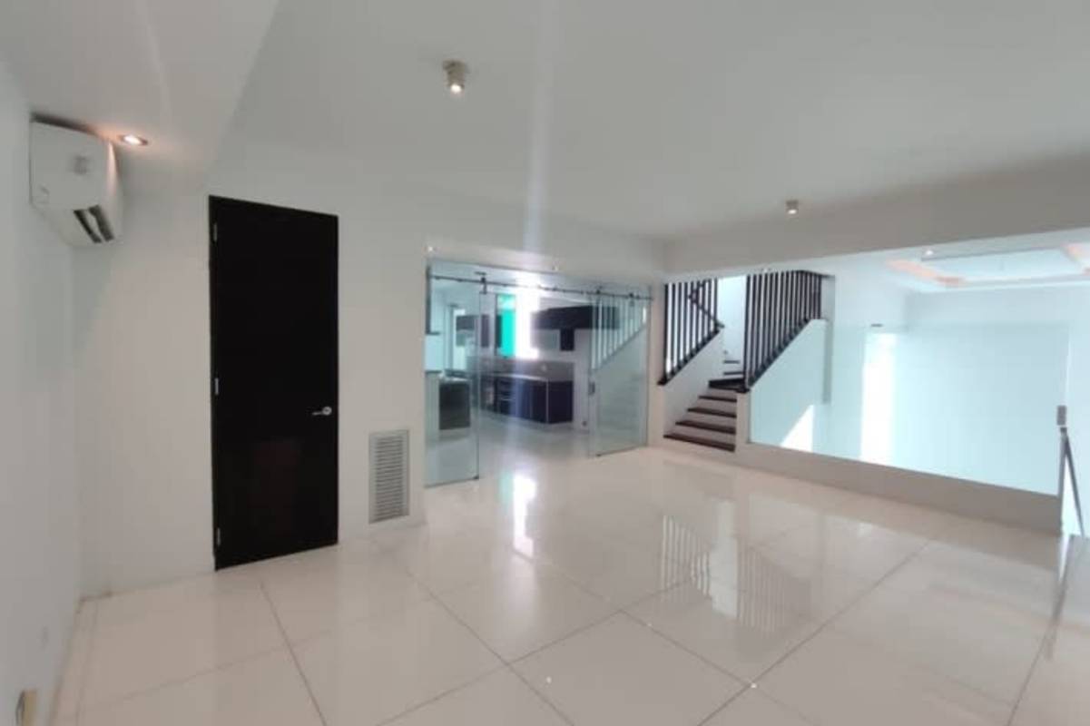 Spacious double-height living room with natural light and minimalist design in luxury PH Altos del Golf house Panama