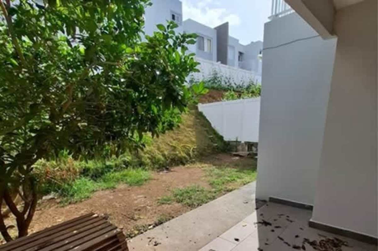 Private garden patio in townhouse with tree and fence in Panama