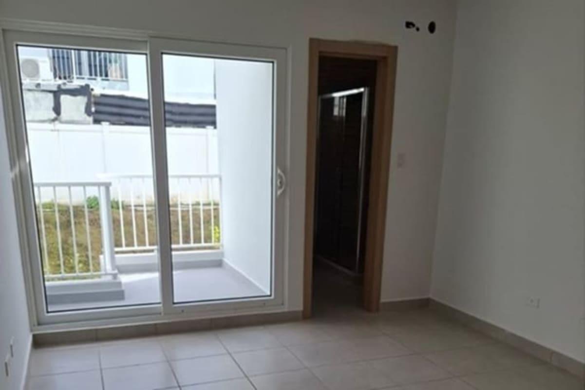 Bright bedroom with tiled floors balcony door and natural lighting Panama house