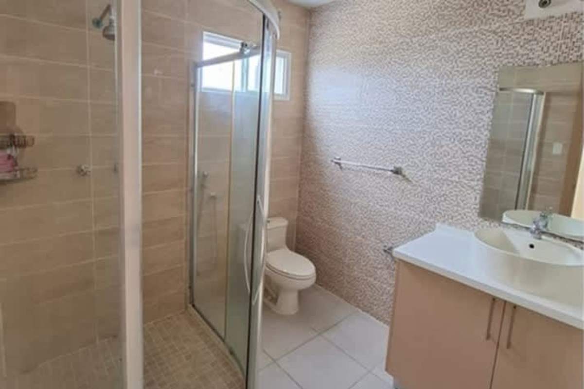 Bathroom with mosaic accent tiles glass enclosed shower and vanity Panama