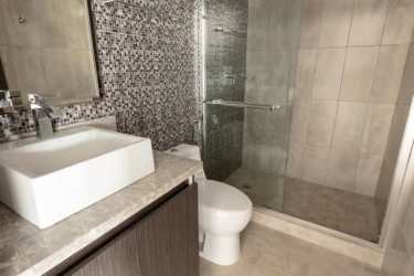 Living room with sliding glass doors to balcony overlooking nature in Tucan Country Club Panama