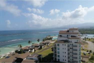 Aerial photo of Playa Escondida beachfront condominiums with palm trees and white sand beach in Colon Panama