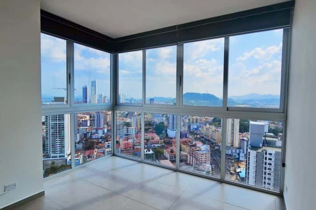 High-rise apartment corner with floor-to-ceiling windows and panoramic city skyline view at PH Signature Point
