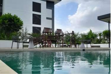 Outdoor pool area and children's playground at The District Costa Verde residential complex