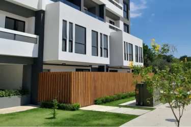 Modern multi-story apartment building with balconies and large windows at The District Costa Verde