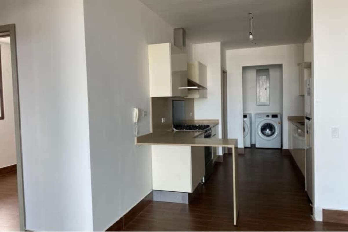 Integrated kitchen and laundry space with appliances in Costa Sur Panama City apartment for sale