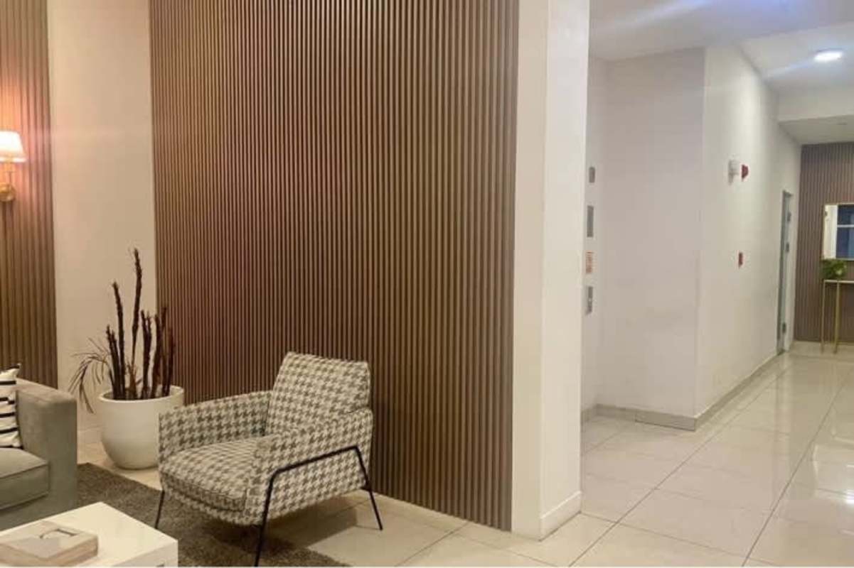 Stylish lobby with wood accent walls, lounge sofas, plants and art PH Gaudí by Haus Panama City