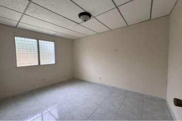 Simple bathroom with tiled walls and glass block window in La Chorrera house