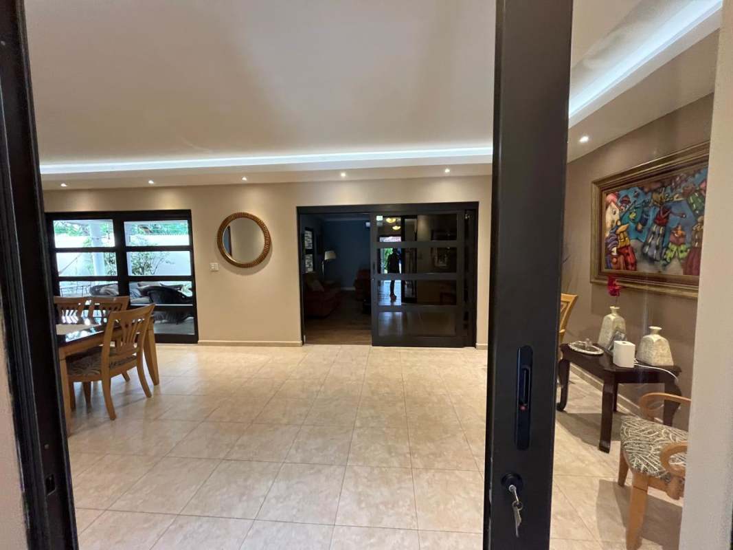 Modern dining room with beige tiles and large glass sliding doors Costa del Este