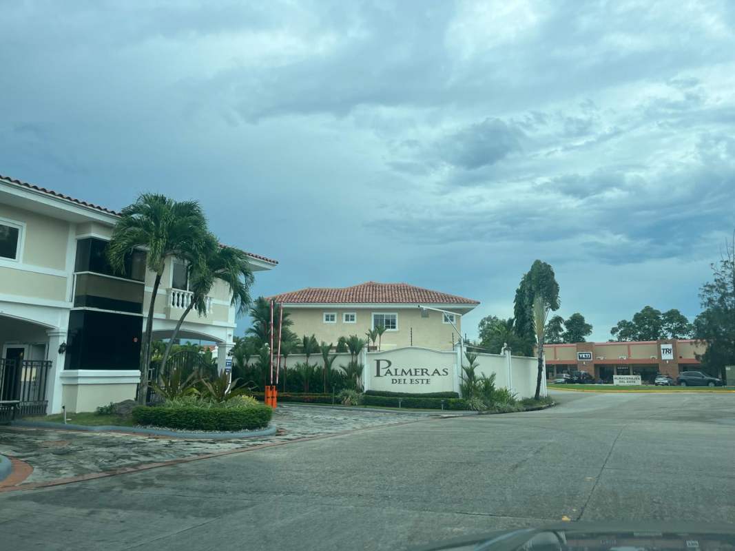 Traditional living room with wood panel wall, TV, brown sofas Costa del Este Panama