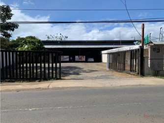 Small commercial storefront with adjacent driveway and vegetation in La Chorrera