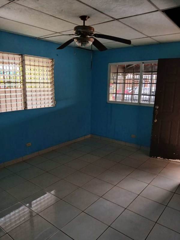 Living room with security barred windows, tiled floor and blue walls Las Cumbres Panama house