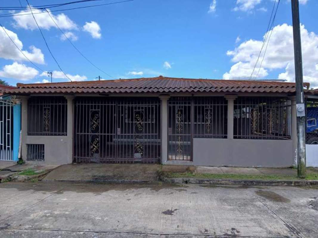 Single story house with tiled roof, metal security bars, front terrace and gated parking La Providencia Panama