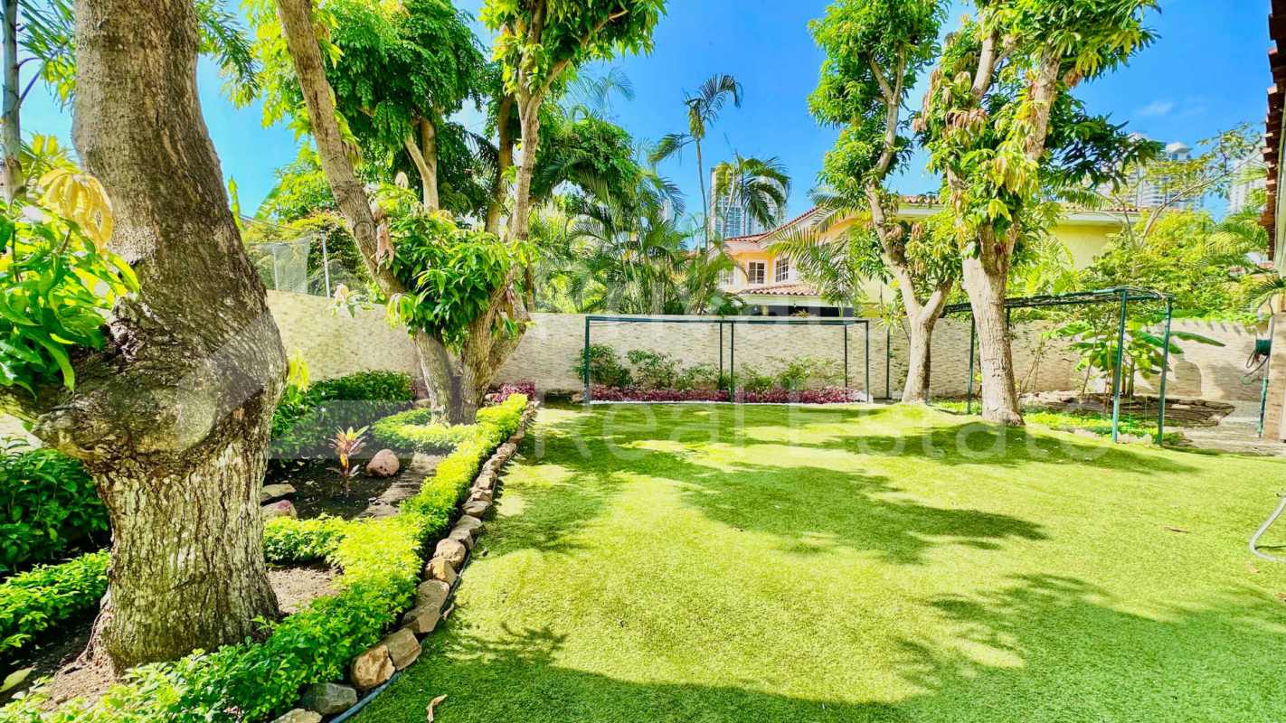 Curved swimming pool illuminated with patio bar in Costa Serena mansion Costa del Este Panama