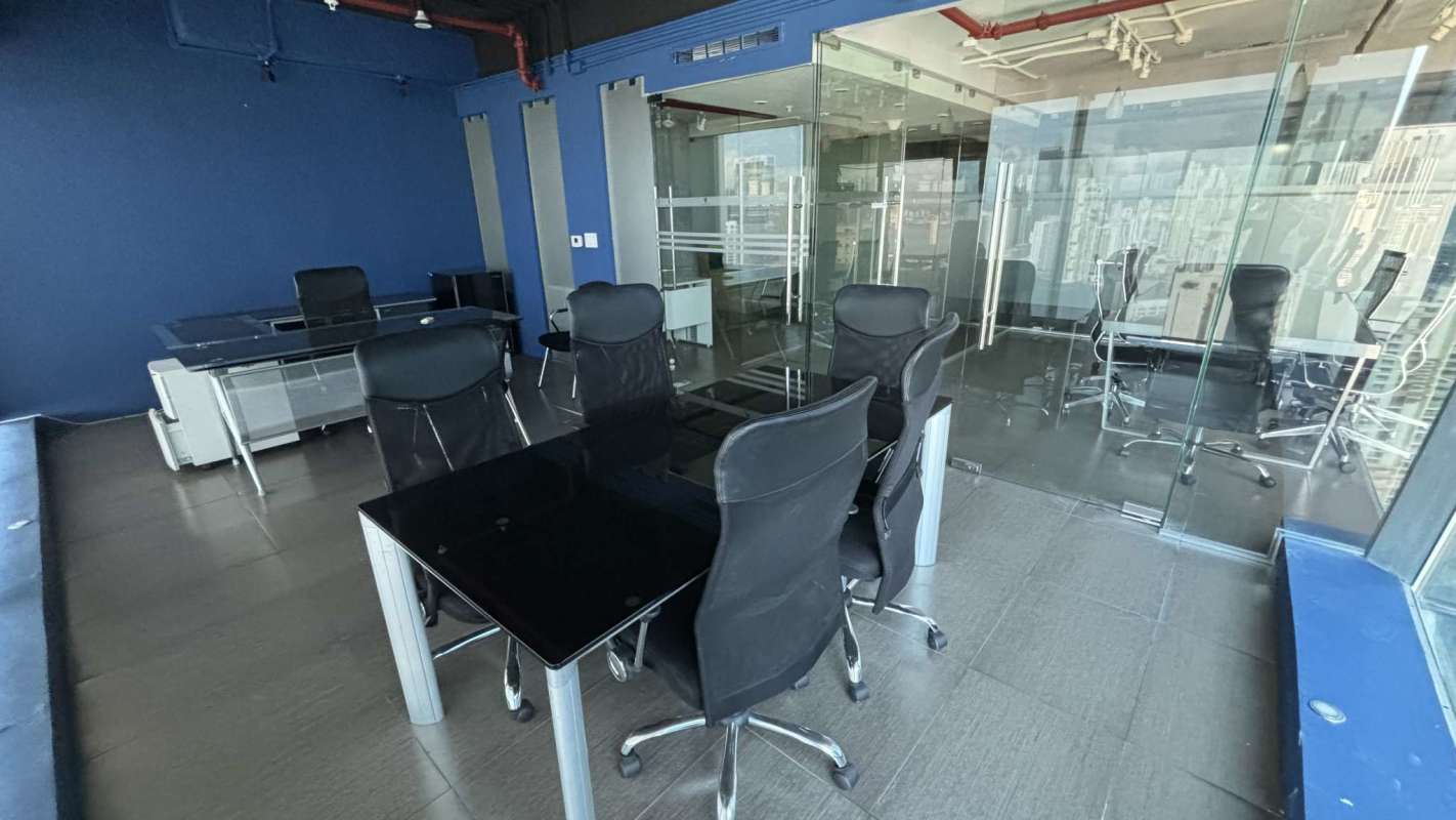 Office workspace with glass partitions and blue accent walls in Oceania Business Plaza Punta Pacífica Panama City