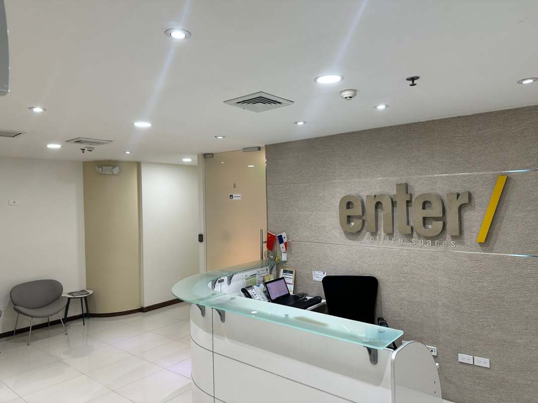 Curved reception desk with glass panel and brand signage at Oceania Business Plaza Tower 1000